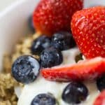Close-up of fresh blueberries and strawberries on yogurt with granola.